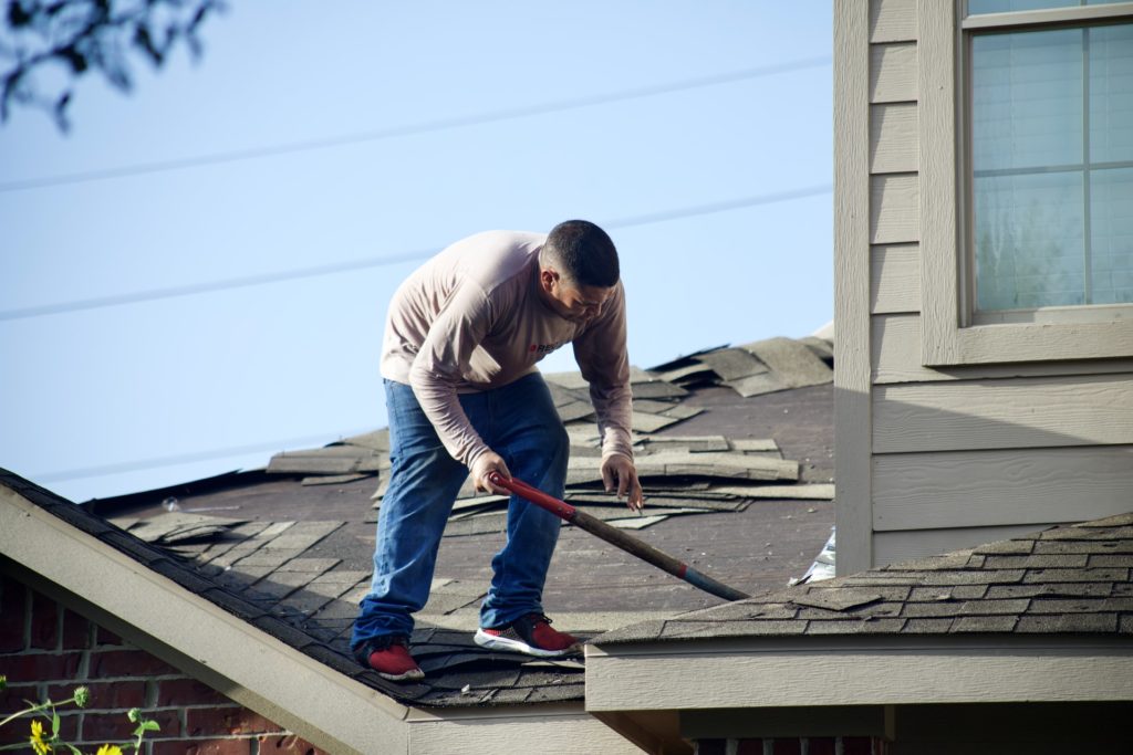 roofer checking out roof damage after a storm